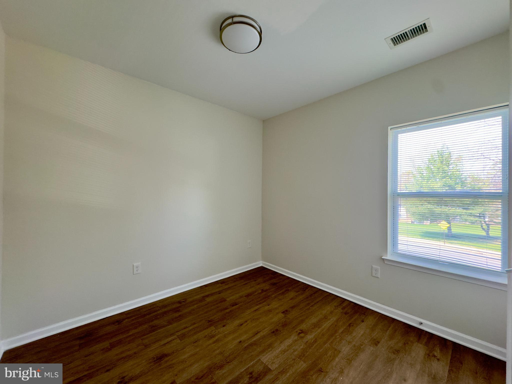 4901 Hamilton Avenue, Unit 4901B Baltimore, MD 21206 - Photo 9 of 10 an empty room with wooden floor and windows