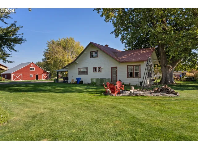 a view of a house with a small yard and sitting area