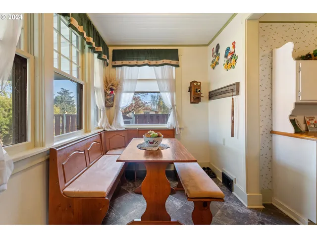 a kitchen with stainless steel appliances granite countertop a refrigerator a sink dishwasher a stove and a dining table with wooden floor