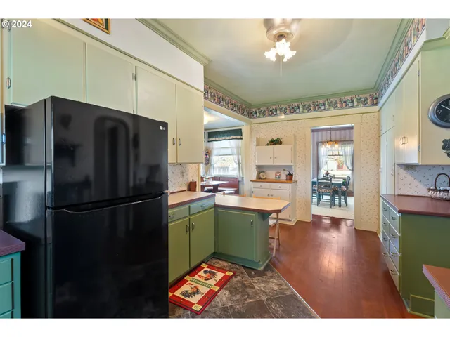 a bedroom with a bed and dresser with wooden floor
