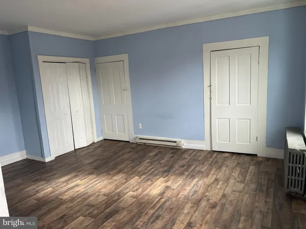 a view of a hallway with wooden floor and stairs