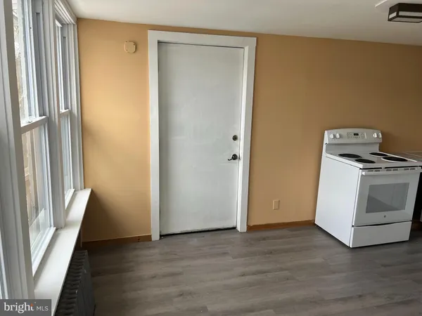 a view of a kitchen with white cabinets and wooden floor