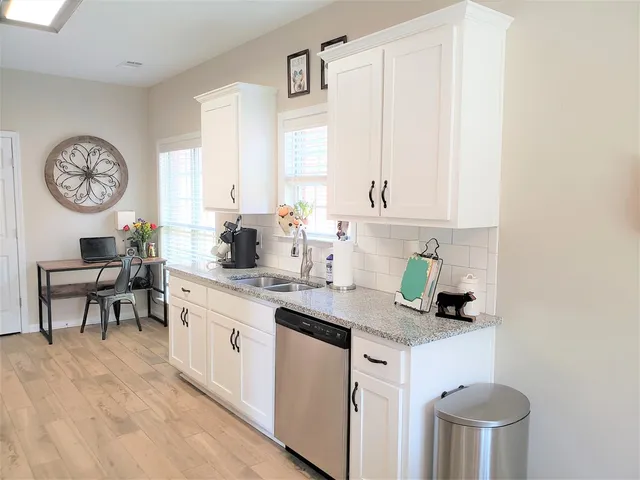 a kitchen with stainless steel appliances granite countertop a refrigerator stove and sink