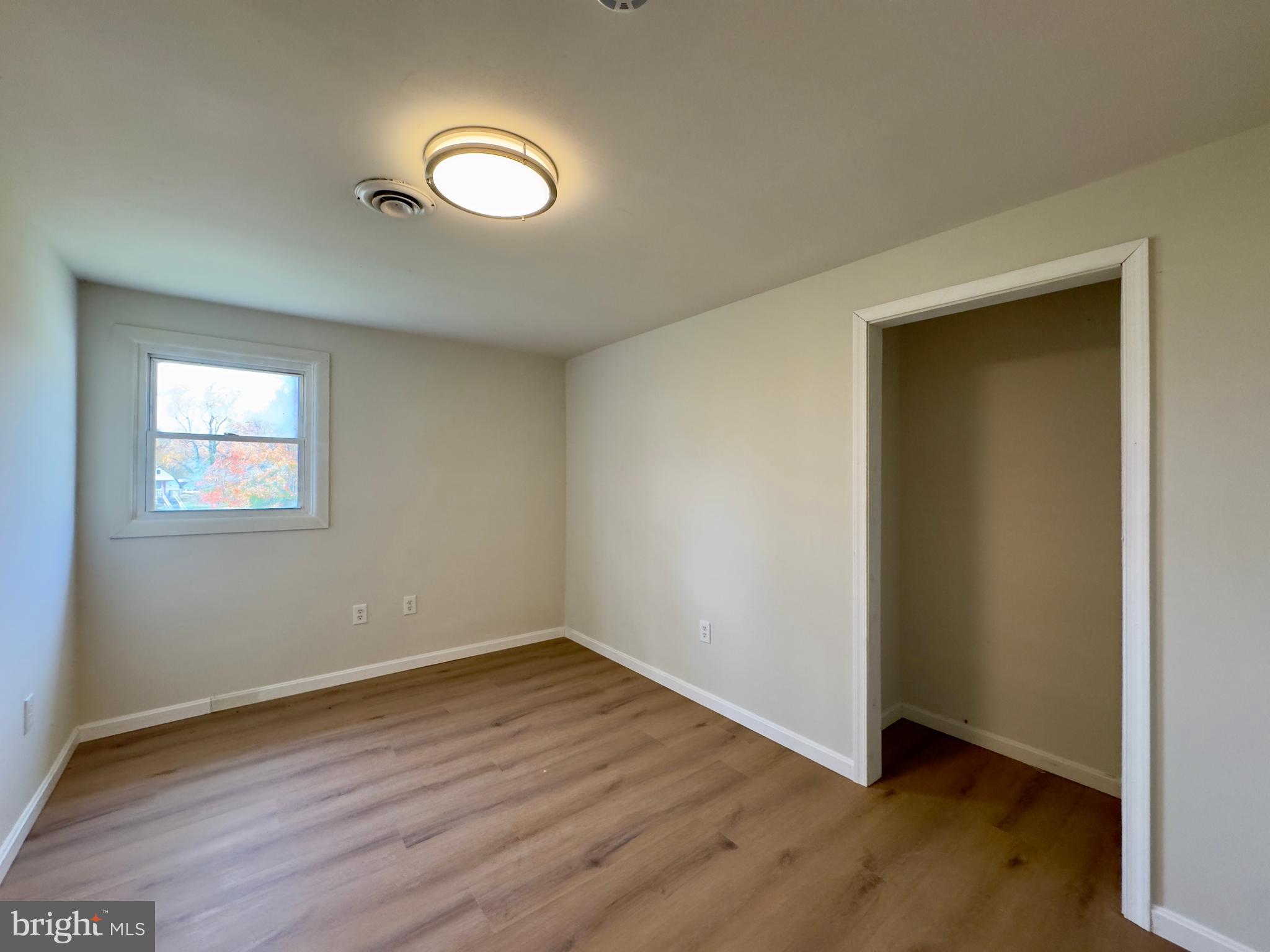815 Seneca Park Road Middle River, MD 21220 - Photo 14 of 23 an empty room with wooden floor and windows