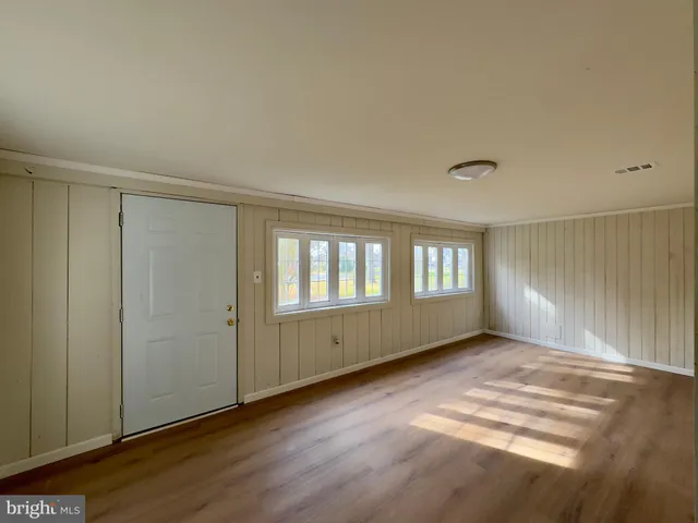 a view of a hallway with wooden floor and stairs