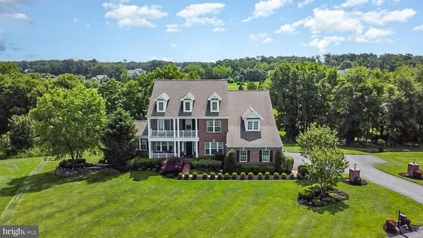 a view of a house with a big yard and large trees