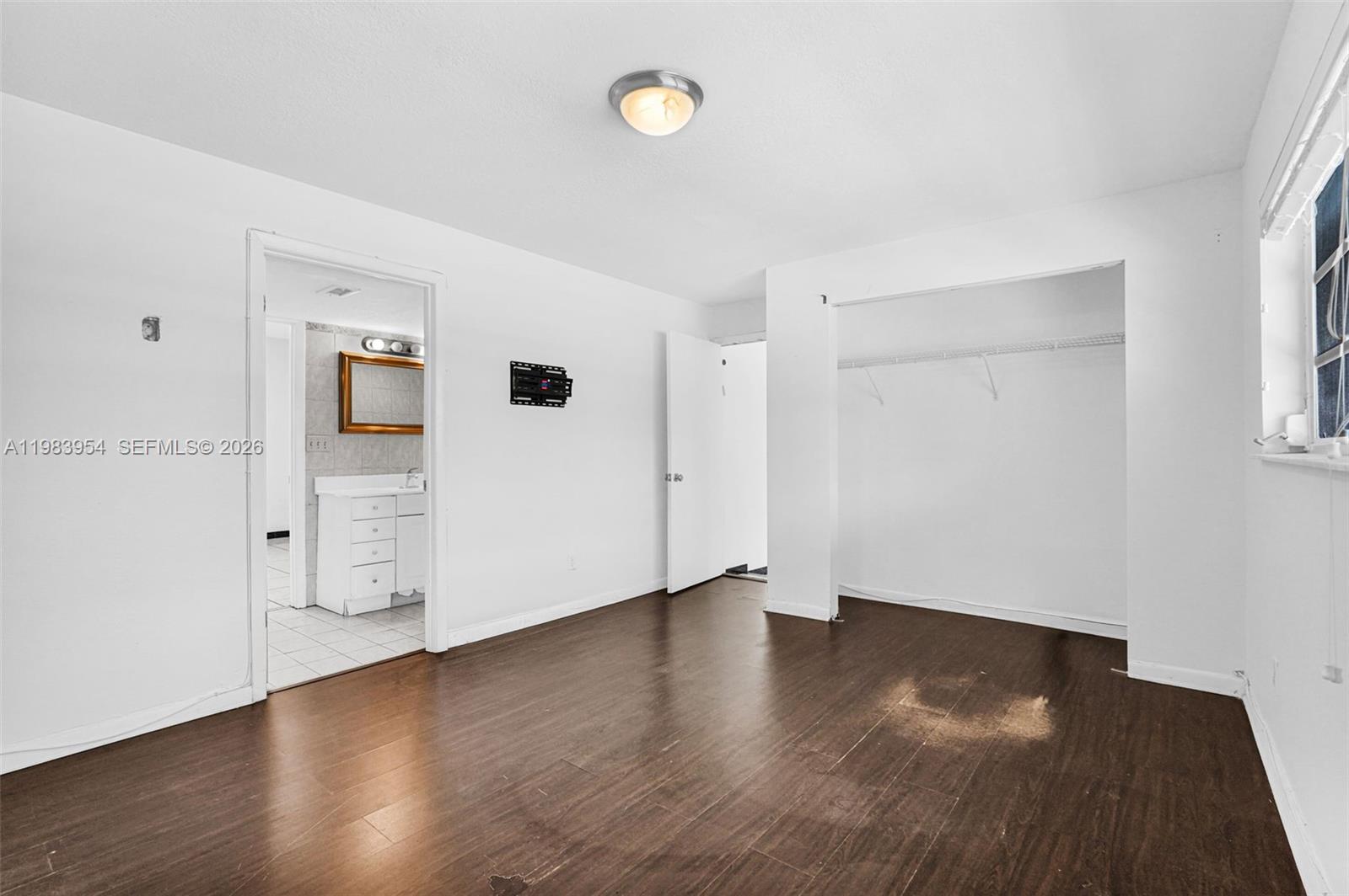 4560 Prairie Avenue Miami Beach, FL 33140 - Photo 11 of 15 an empty room with wooden floor and windows