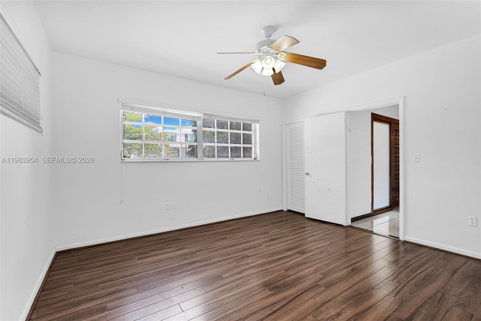 4560 Prairie Avenue Miami Beach, FL 33140 - Photo 12 of 15 a view of an empty room with wooden floor and a window