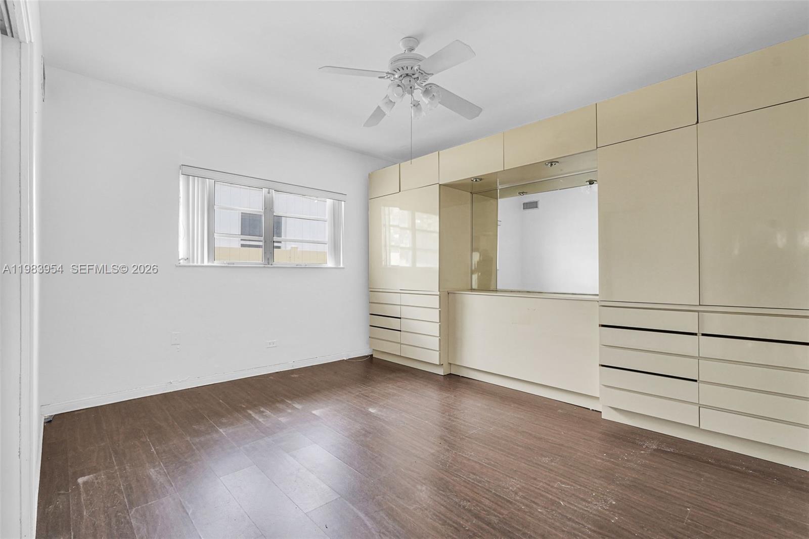 4560 Prairie Avenue Miami Beach, FL 33140 - Photo 13 of 15 an empty room with wooden floor cabinet and windows