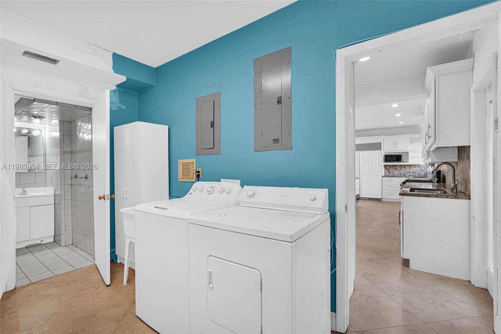 4560 Prairie Avenue Miami Beach, FL 33140 - Photo 7 of 15 a kitchen that has a refrigerator a sink and white cabinets