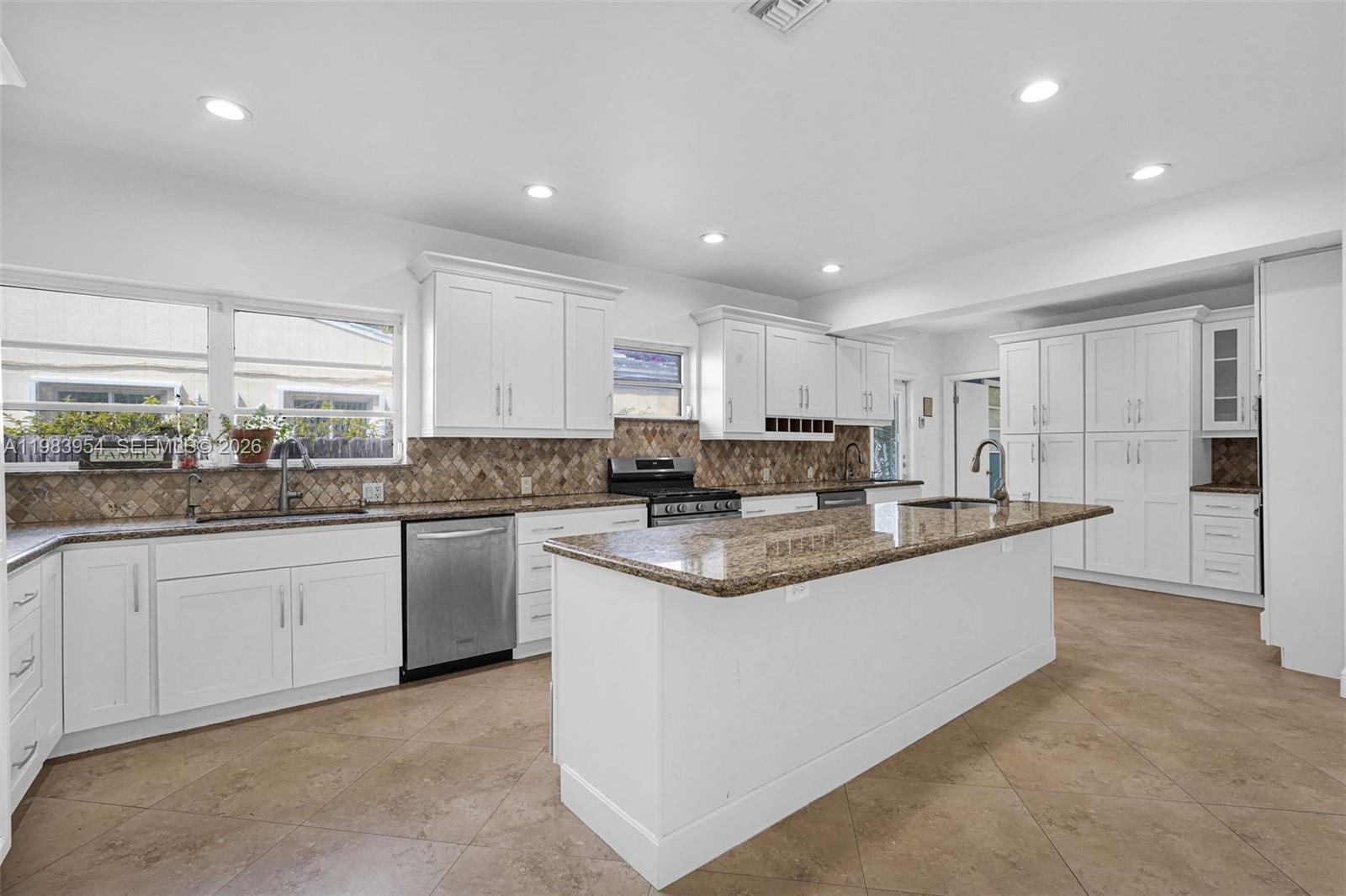 4560 Prairie Avenue Miami Beach, FL 33140 - Photo 9 of 15 a large kitchen with stainless steel appliances granite countertop a sink and cabinets