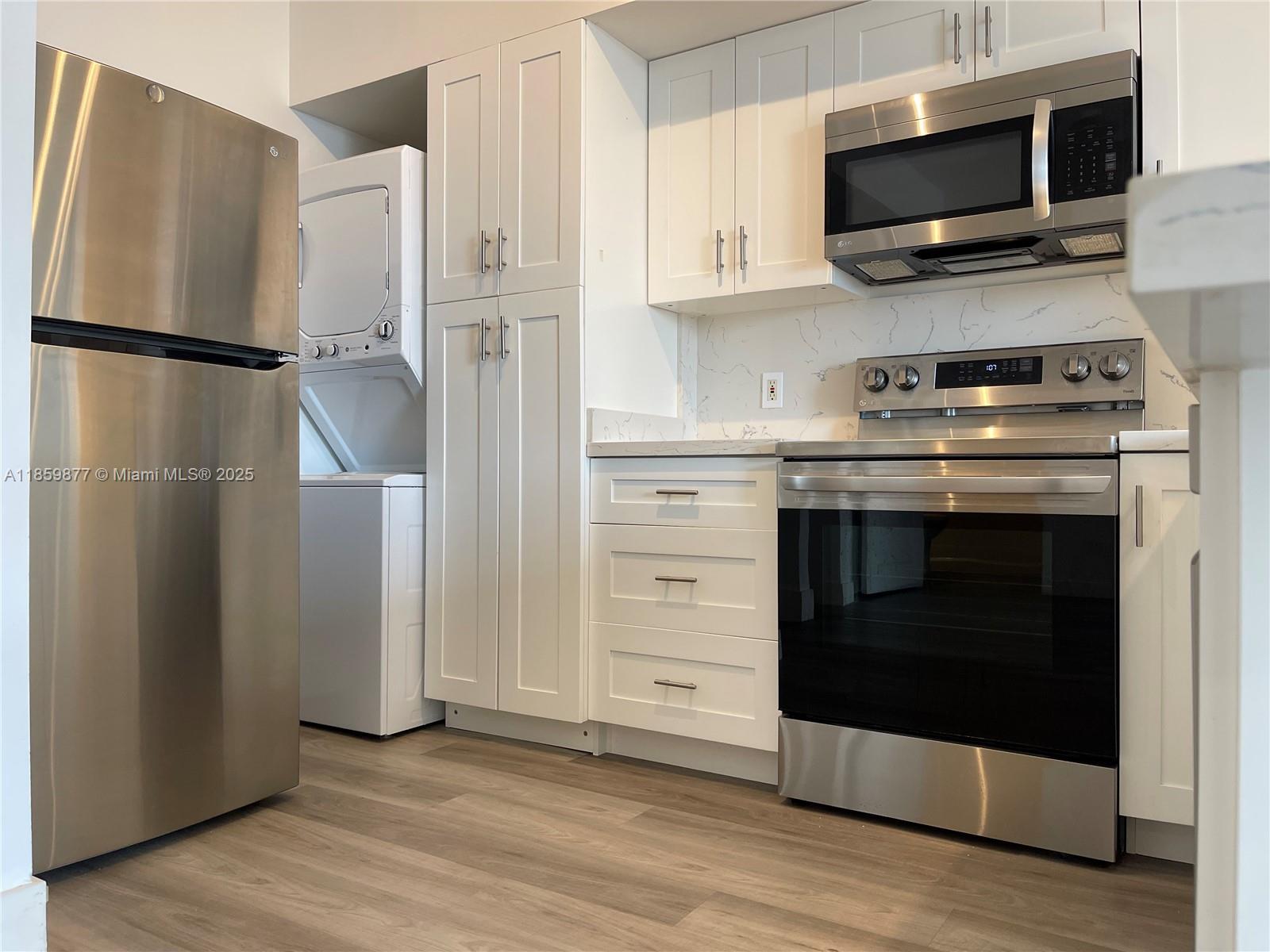 5085 Northwest 7th Street, Unit 1203 Miami, FL 33126 - Photo 11 of 26 a kitchen with stainless steel appliances a stove a microwave and a refrigerator