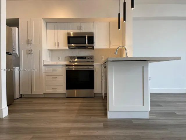 a kitchen with stainless steel appliances a stove microwave and refrigerator
