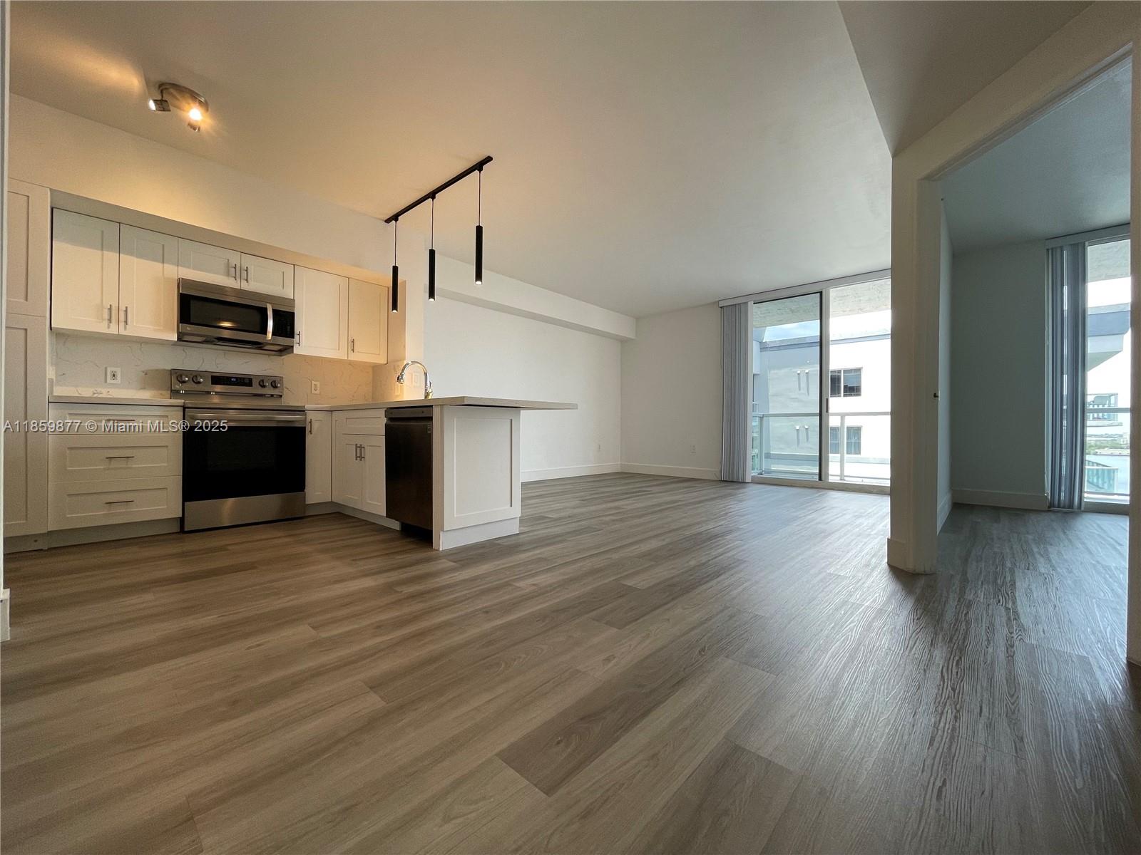 5085 Northwest 7th Street, Unit 1203 Miami, FL 33126 - Photo 13 of 26 a view of kitchen with microwave and stove