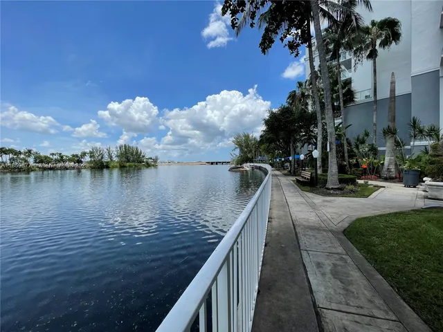 a view of a lake with a floor to ceiling window next to a building