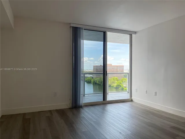 an empty room with wooden floor and sliding door