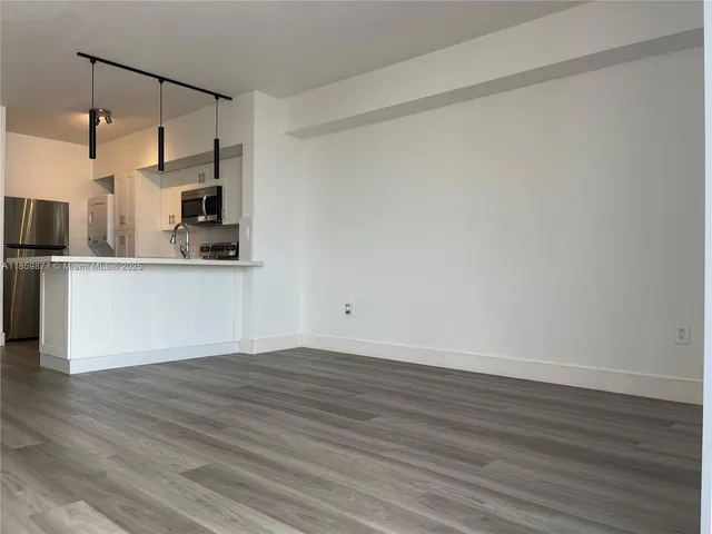 a view of a kitchen with wooden floor and a sink