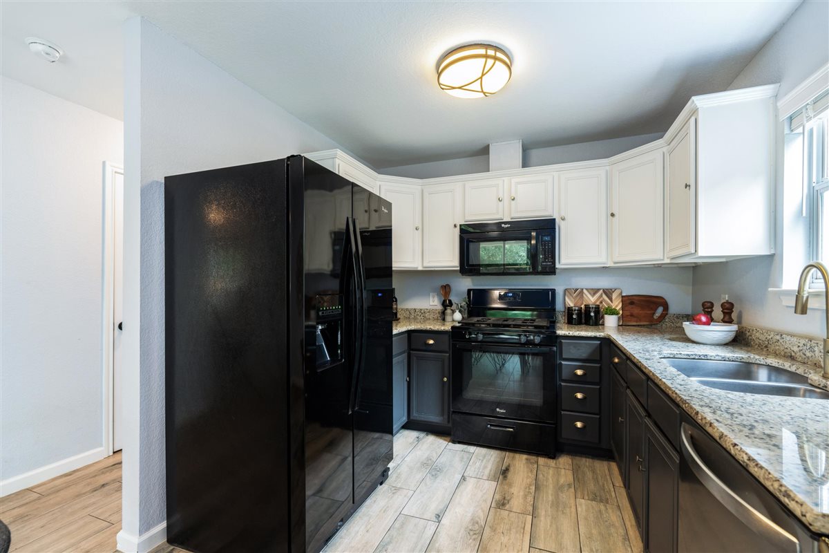 2147 Jasmine Path Round Rock, TX 78664 - Photo 13 of 36 Two-tone cabinetry — white uppers and dark lowers — delivers a modern, updated aesthetic.