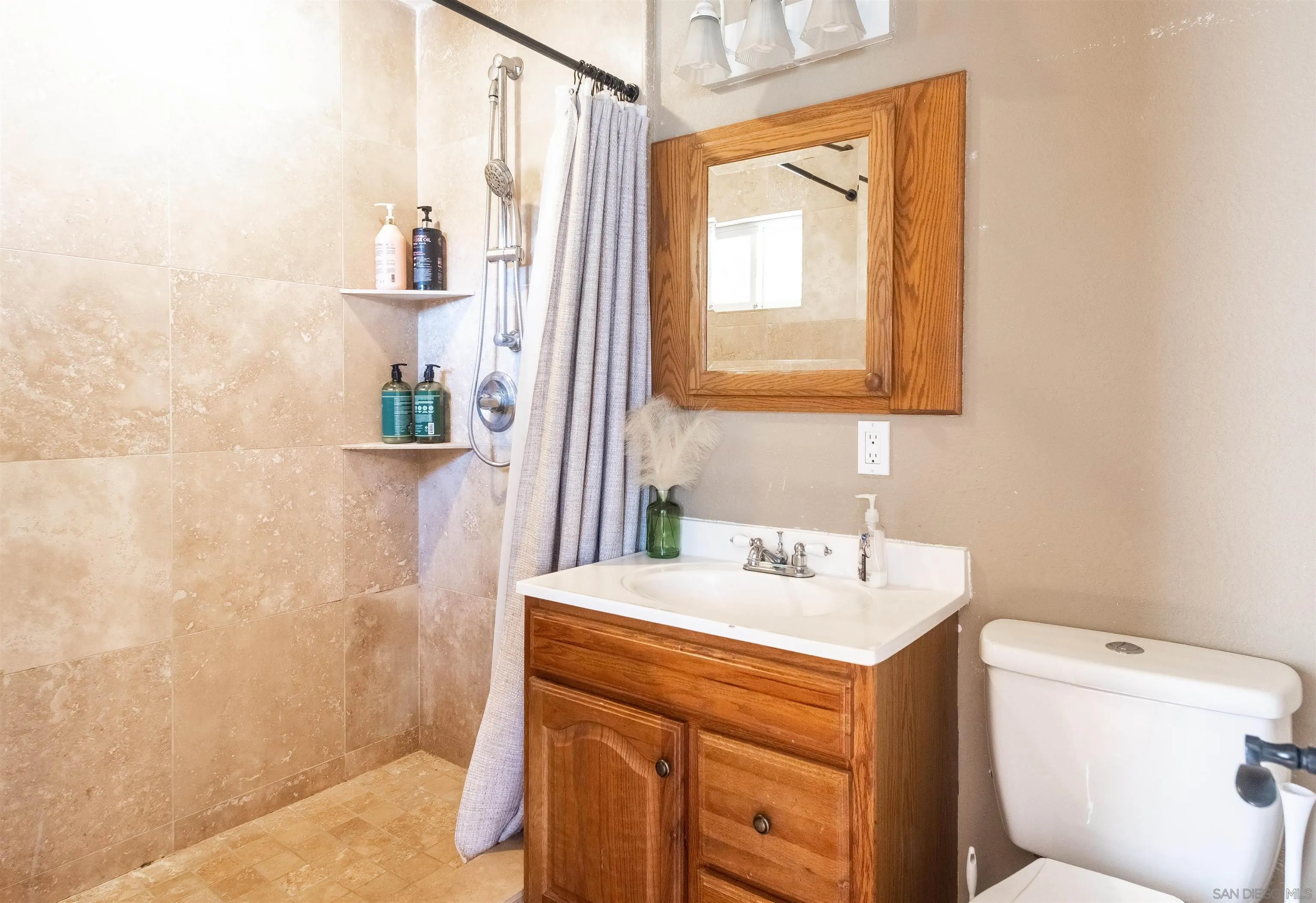 853 Crescent Drive Vista, CA 92084 - Photo 34 of 70 a bathroom with a sink a toilet and shower curtain