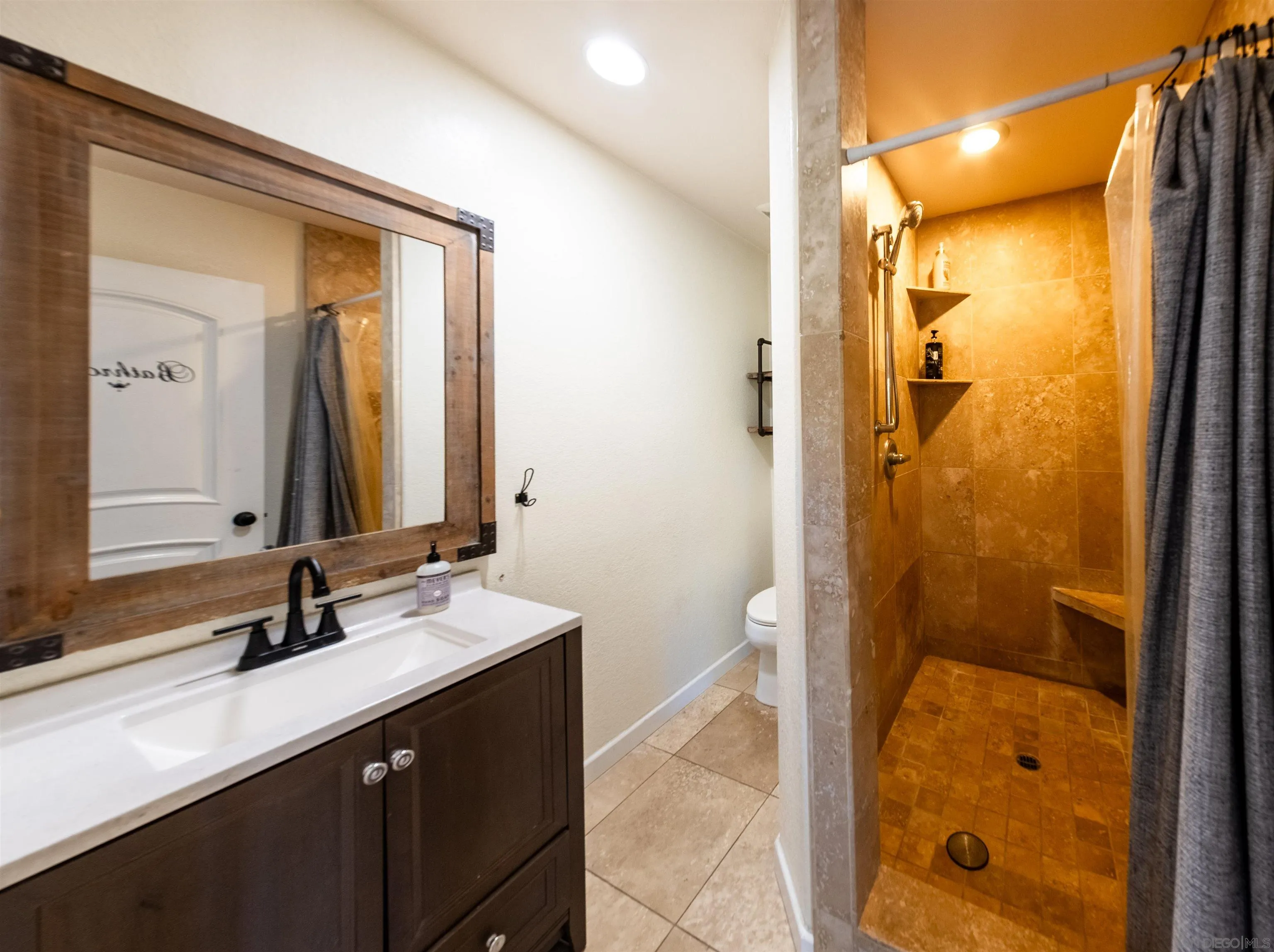 853 Crescent Drive Vista, CA 92084 - Photo 48 of 70 a bathroom with a shower sink and mirror
