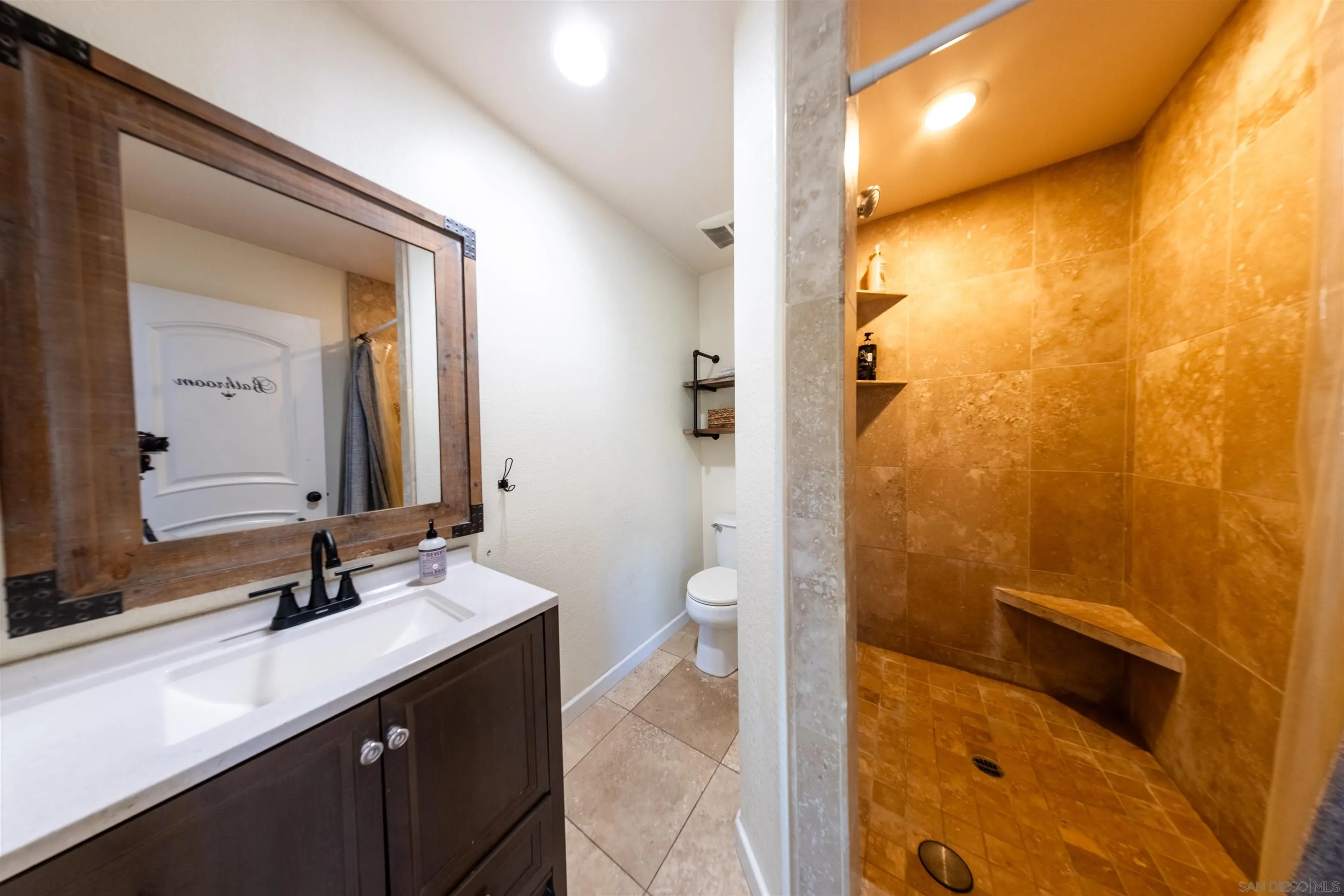 853 Crescent Drive Vista, CA 92084 - Photo 49 of 70 a bathroom with a sink a toilet and shower