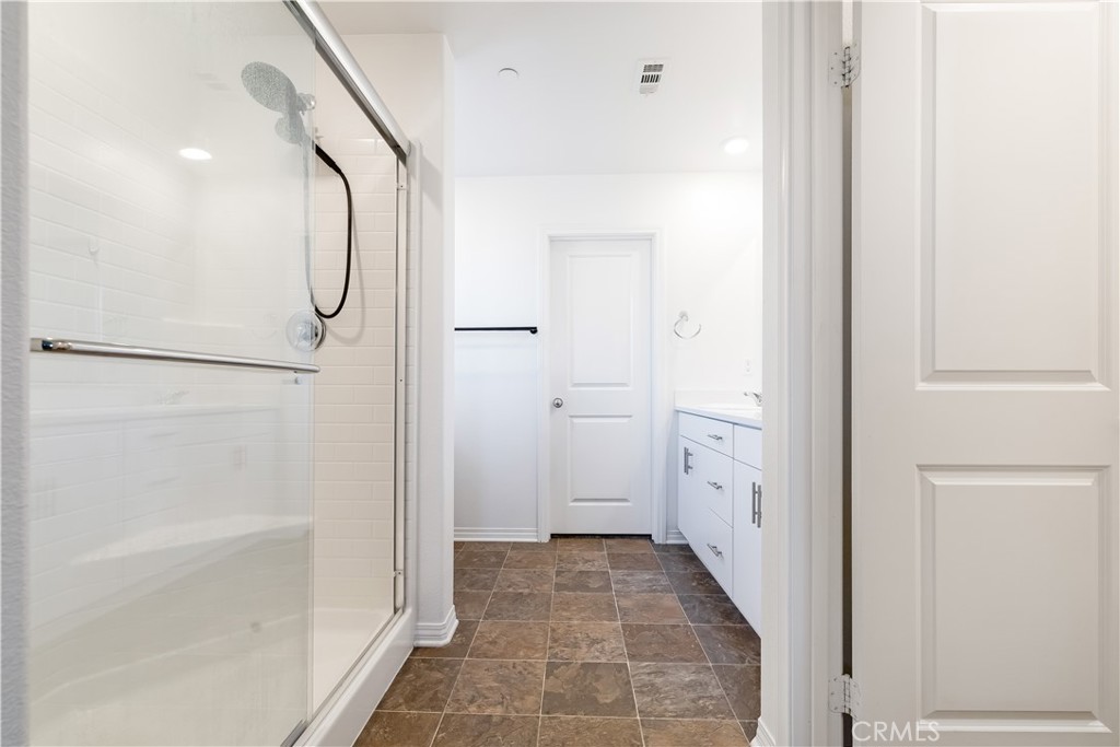 2498 Gunner Ridge Way Rialto, CA 92377 - Photo 14 of 31 a bathroom with a glass door shower and a sink