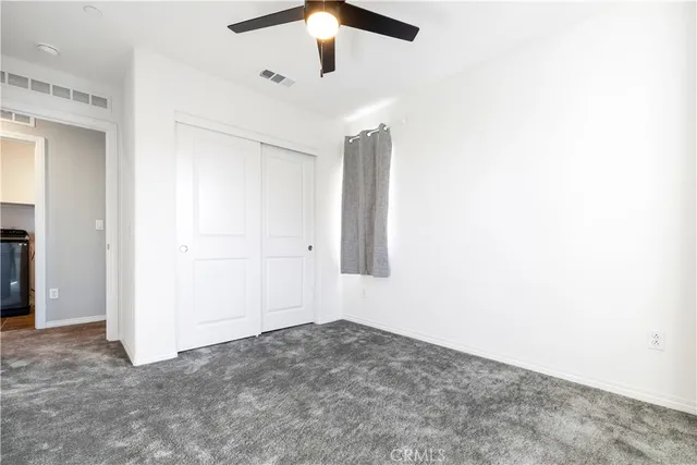 an empty room with a ceiling fan and a window