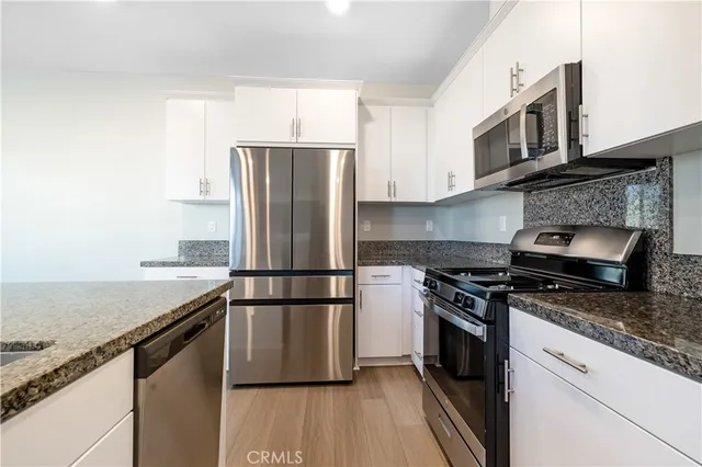 a kitchen with a stove top oven and refrigerator