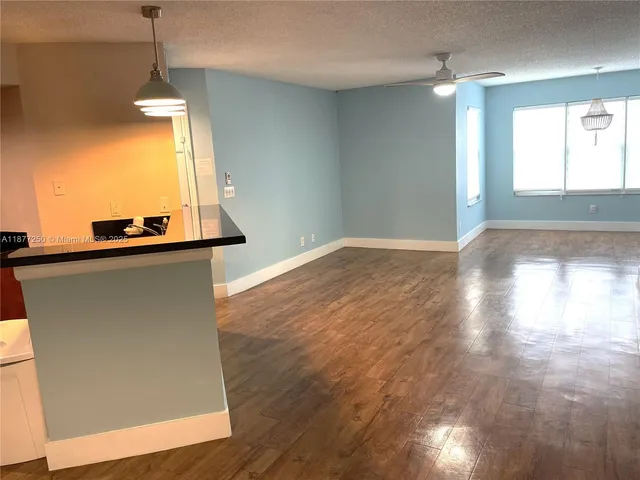 a view of a hallway with wooden floor and a chandelier