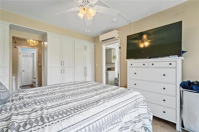 a bedroom with a bed tv and cabinets