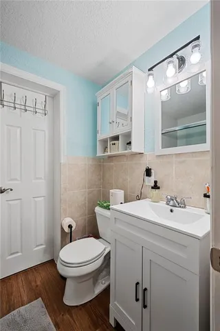 a bathroom with a toilet a sink and mirror