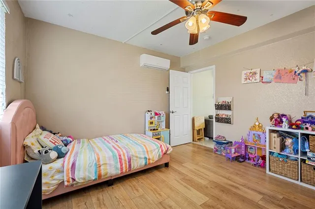 a bedroom with bed and a wooden floor