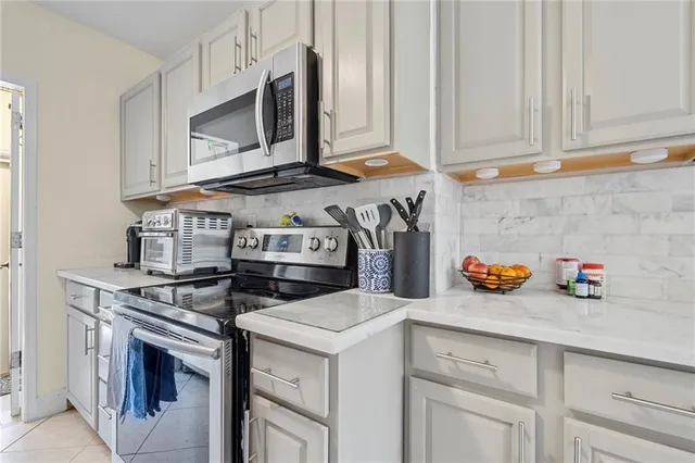 a kitchen with stainless steel appliances granite countertop a stove a microwave and cabinets