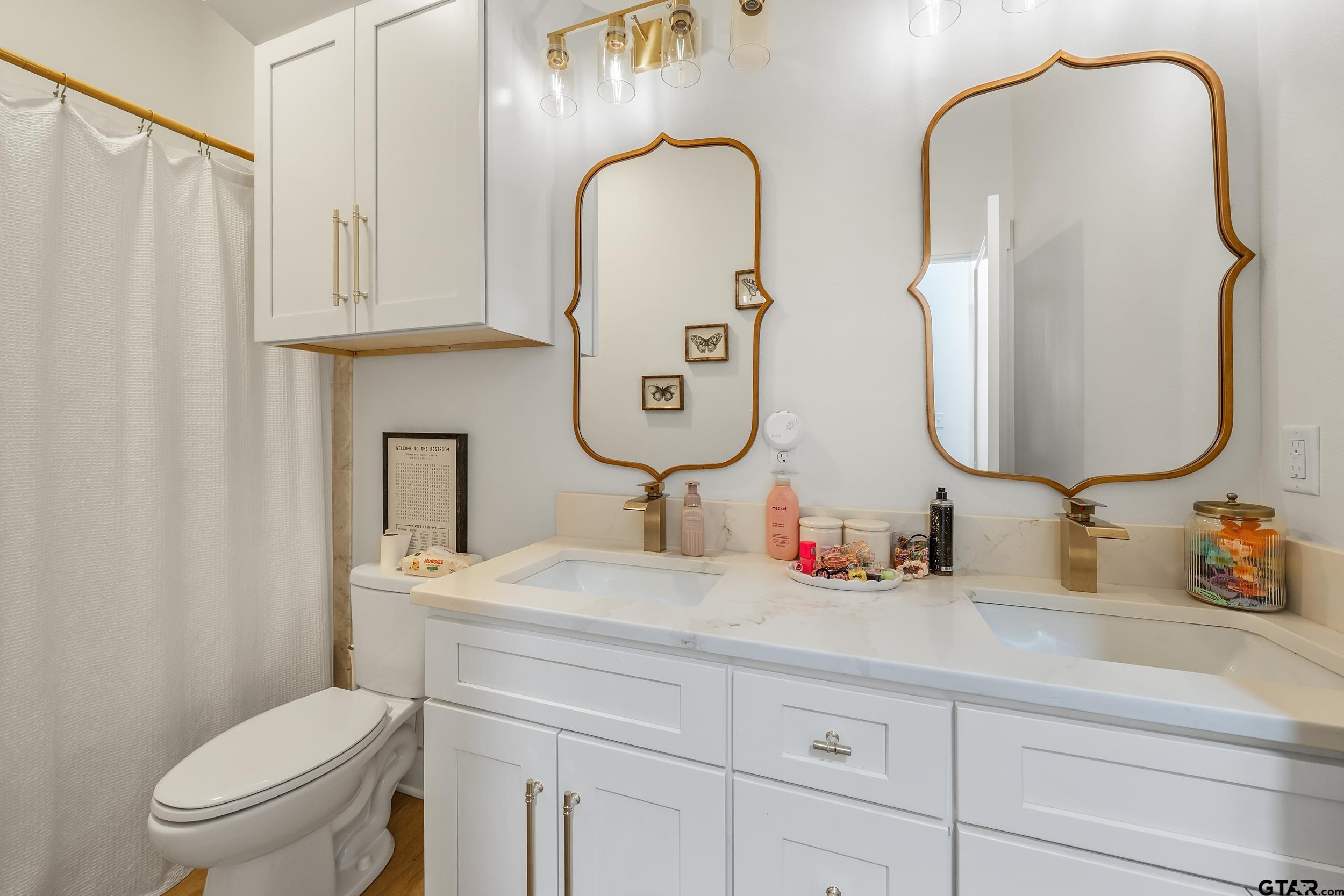 16837 Wilson Road Tyler, TX 75707 - Photo 31 of 44 a bathroom with double vanity sink toilet and a mirror