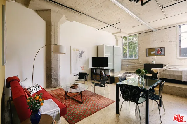 a living room with furniture a flat screen tv and a floor to ceiling window