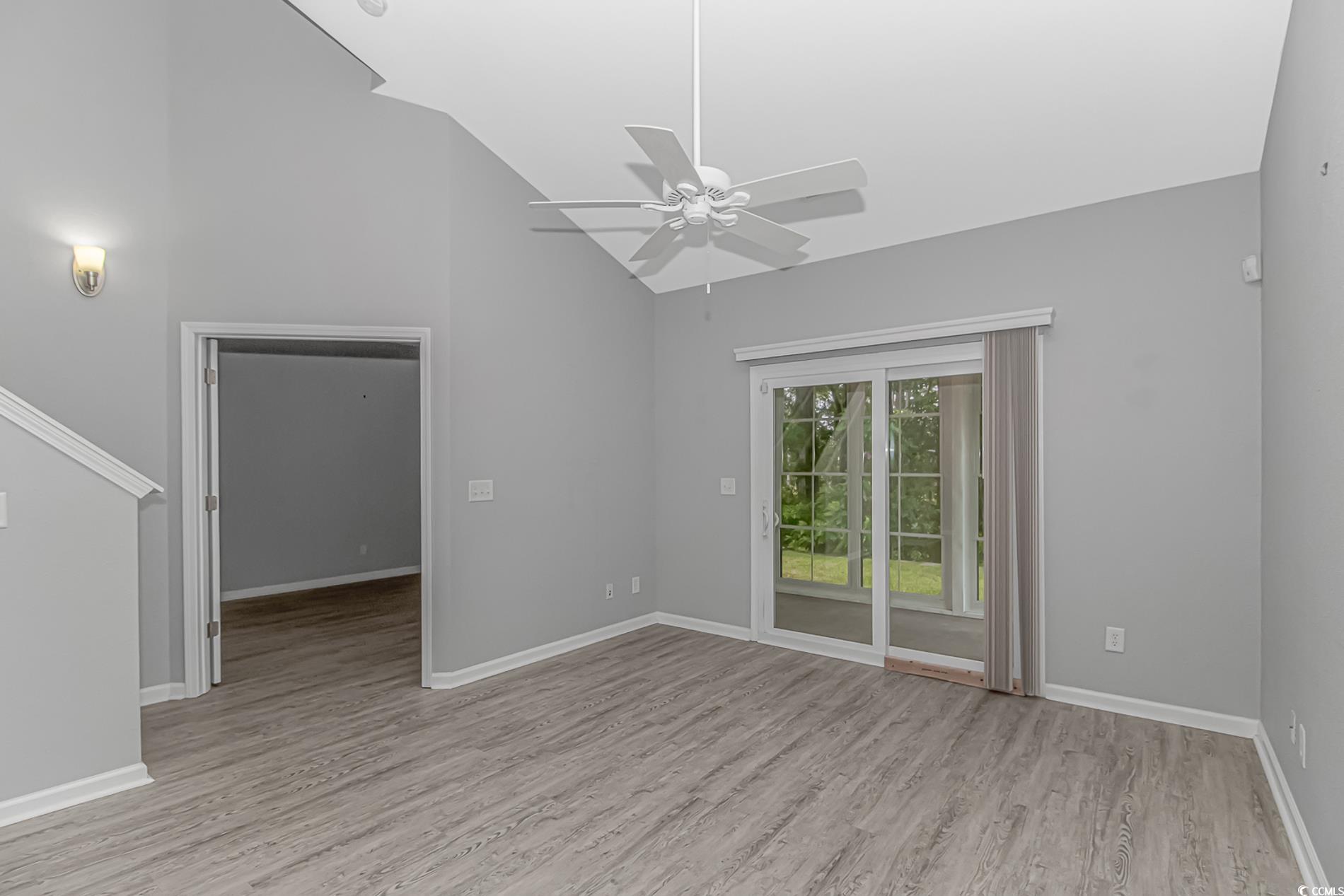 751 Painted Bunting Drive, Unit E Murrells Inlet, SC 29576 - Photo 17 of 40 Unfurnished room featuring ceiling fan, wood finished floors, baseboards, and high vaulted ceiling