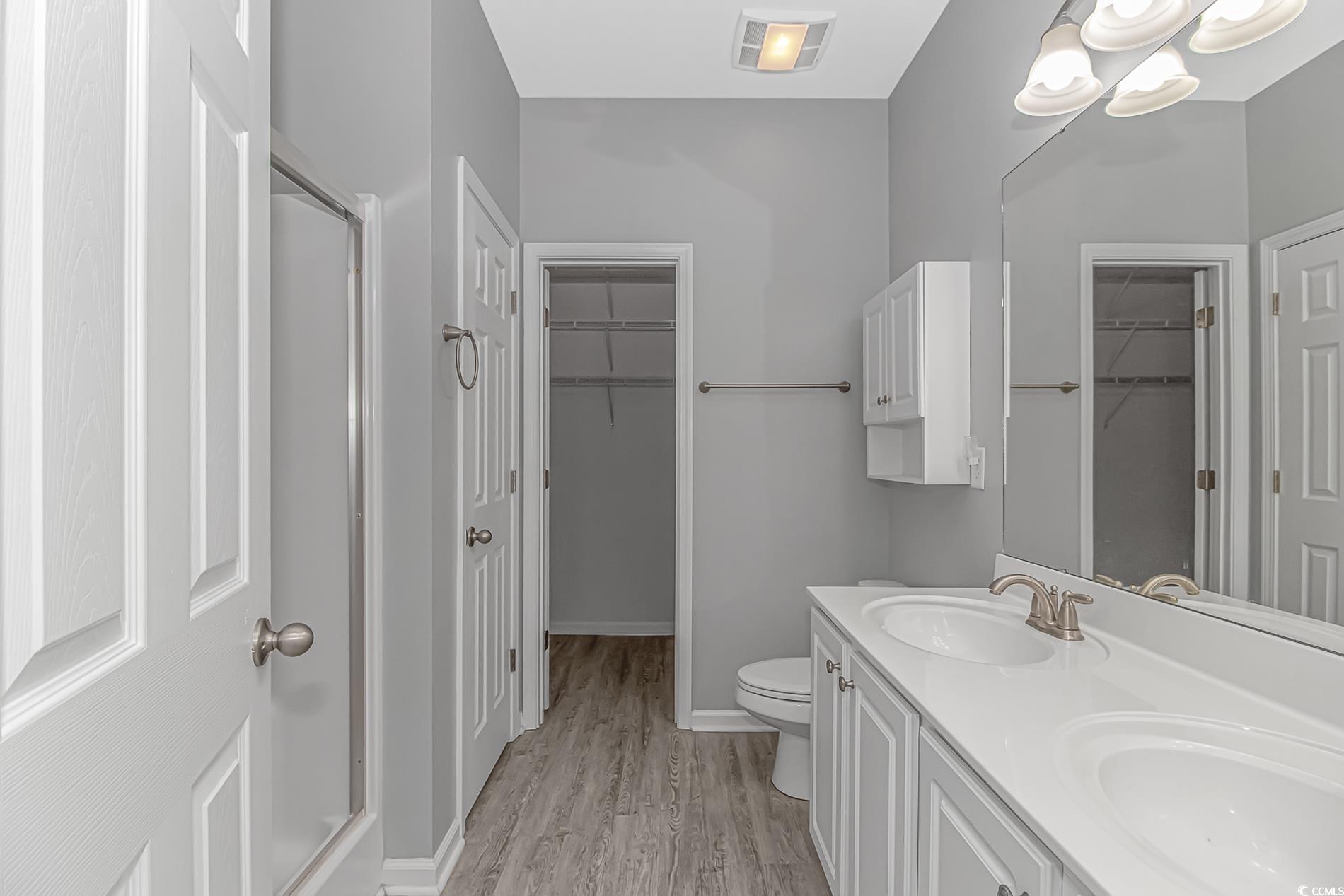 751 Painted Bunting Drive, Unit E Murrells Inlet, SC 29576 - Photo 22 of 40 Full bathroom featuring toilet, wood finished floors, double vanity, baseboards, and a shower with door