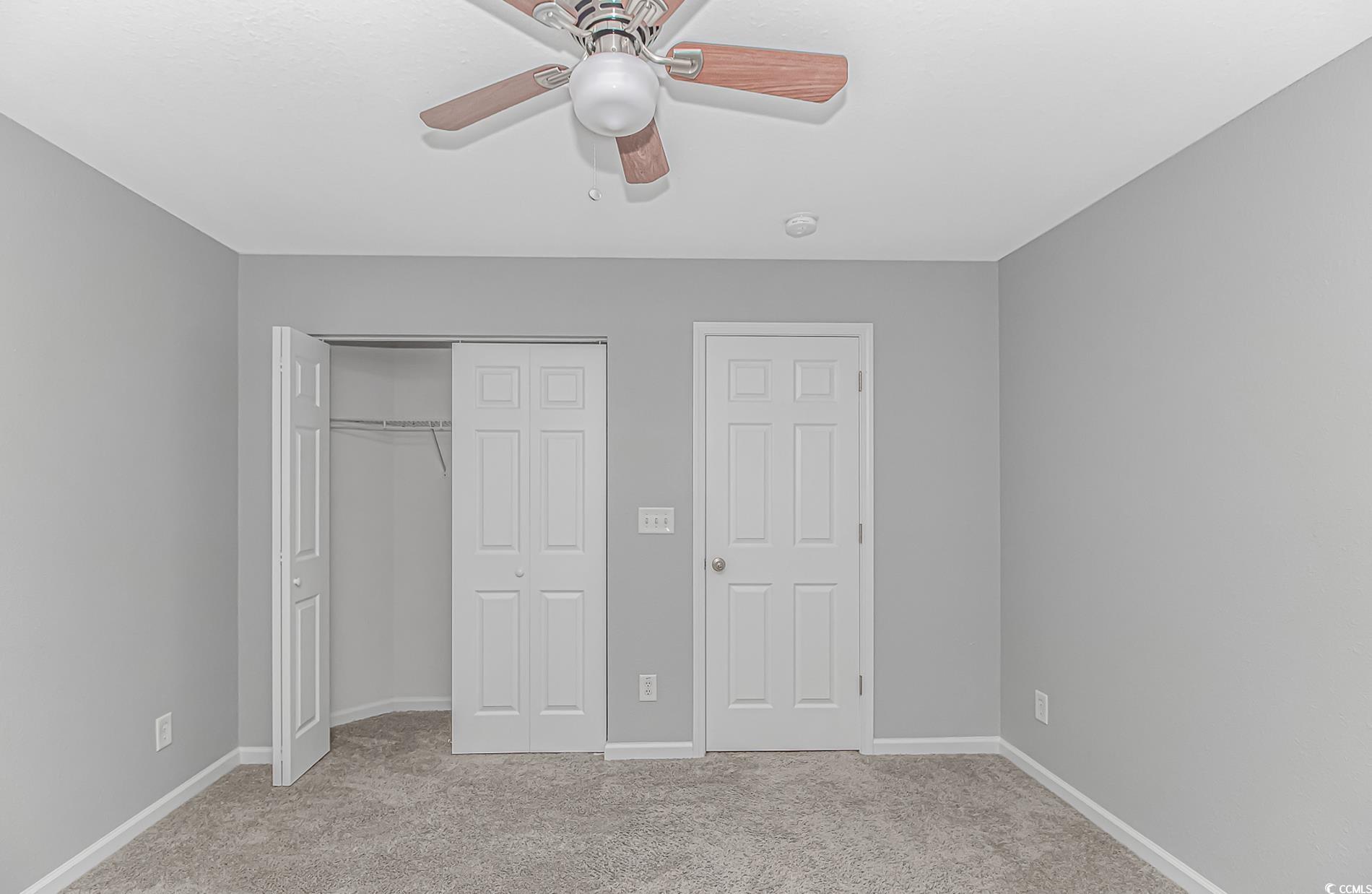 751 Painted Bunting Drive, Unit E Murrells Inlet, SC 29576 - Photo 28 of 40 Unfurnished bedroom featuring light colored carpet, a closet, baseboards, and a ceiling fan