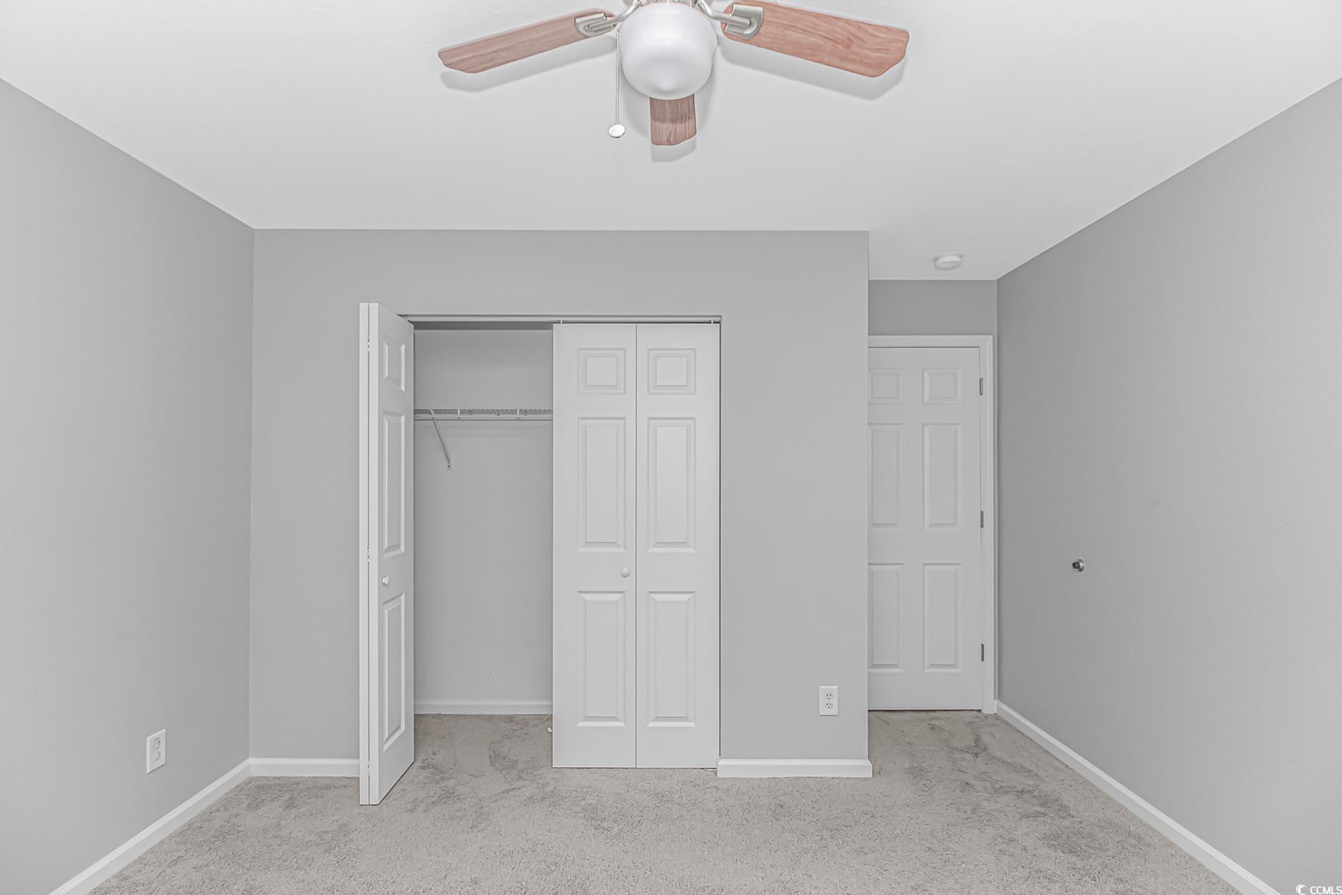 751 Painted Bunting Drive, Unit E Murrells Inlet, SC 29576 - Photo 32 of 40 Unfurnished bedroom featuring carpet floors, a closet, baseboards, and ceiling fan