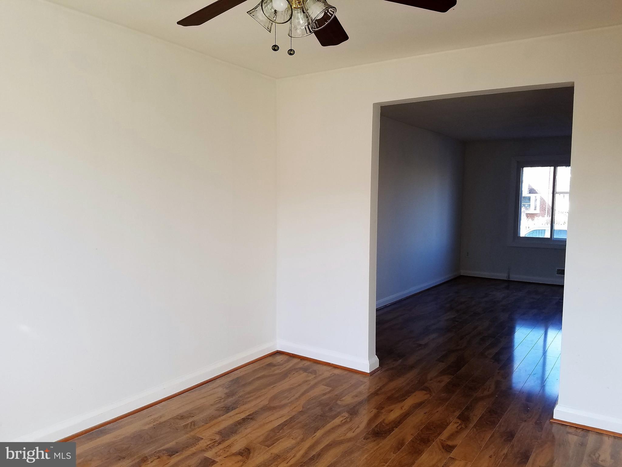 1905 Barry Road Dundalk, MD 21222 - Photo 5 of 23 a view of an empty room with wooden floor and a window