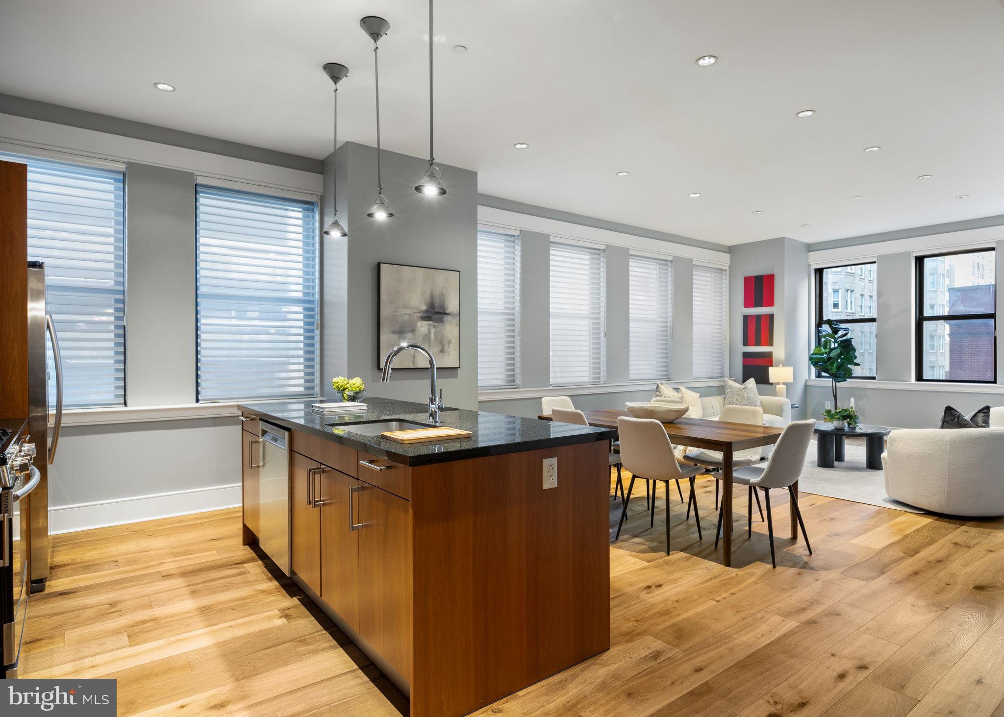 1515 Locust Street, Unit 401 Philadelphia, PA 19102 - Photo 1 of 35 a kitchen with stainless steel appliances granite countertop a stove a sink dishwasher and a dining table with wooden floor