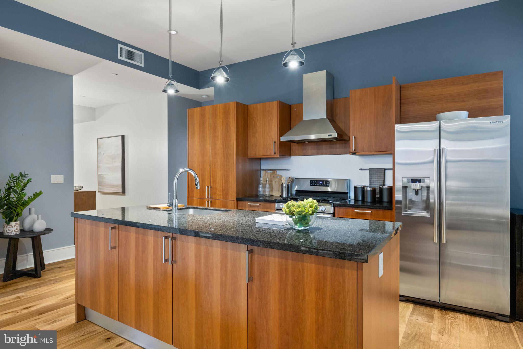 1515 Locust Street, Unit 401 Philadelphia, PA 19102 - Photo 5 of 35 a kitchen with stainless steel appliances granite countertop a sink a refrigerator and a counter space