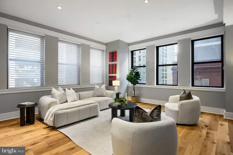a living room with furniture and floor to ceiling windows