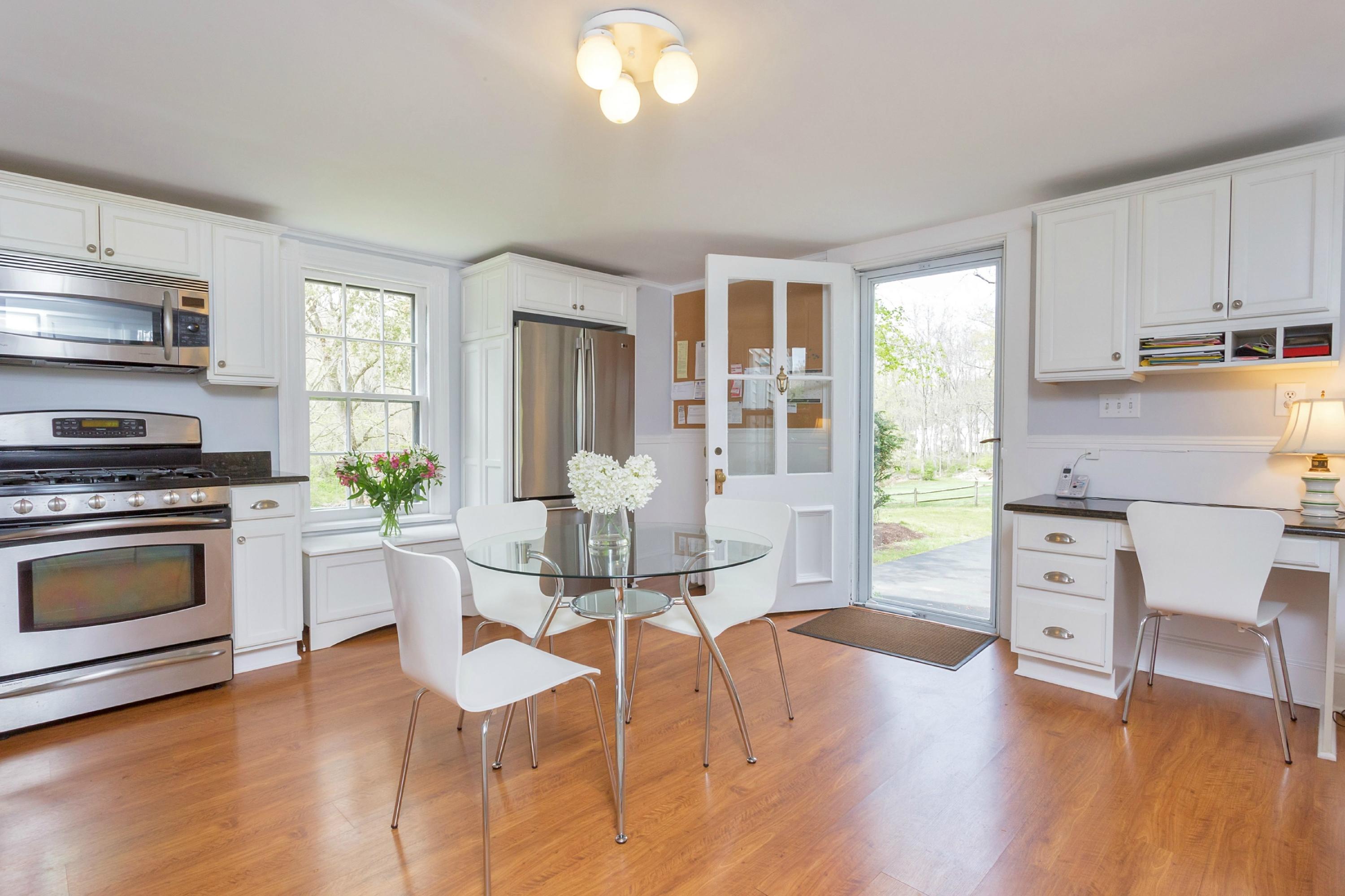 369 Middlesex Road Darien, CT 06820 - Photo 8 of 24 a kitchen with a table chairs stove and cabinets