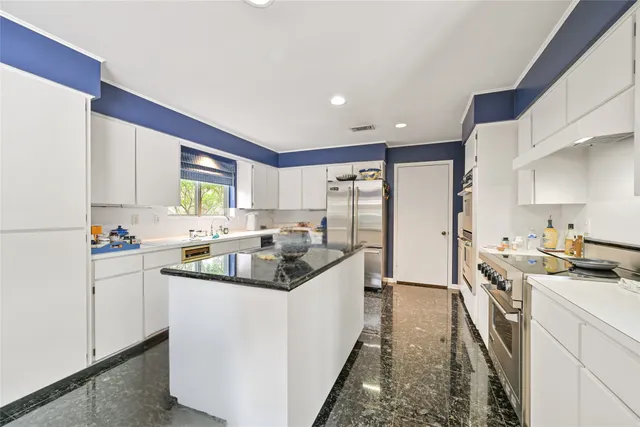 a kitchen with stainless steel appliances a sink stove top oven and cabinets