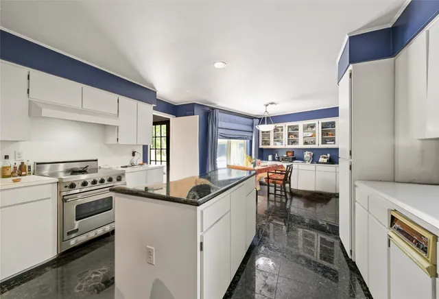 a kitchen with white cabinets and appliances