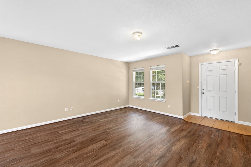 458 Nottingham Loop Kyle, TX 78640 - Photo 15 of 38 a view of an empty room with wooden floor and a window