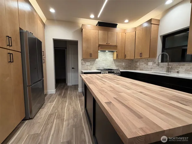 a large kitchen with a sink and refrigerator