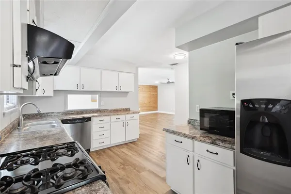 a kitchen with a stove a sink and a microwave