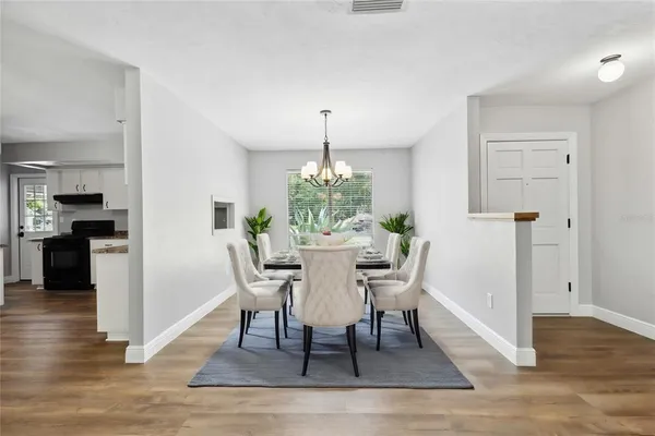 a dining room with furniture potted plants and wooden floor